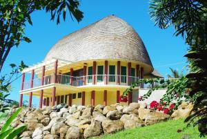 dom z okrągłym dachem na stosie kamieni w obiekcie Samoan Highland Hideaway w mieście Siusega