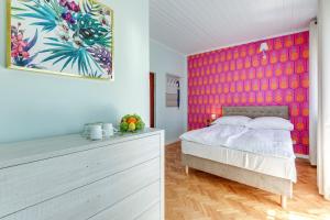 a bedroom with a bed and a colorful wall at Meduza Sopot in Sopot