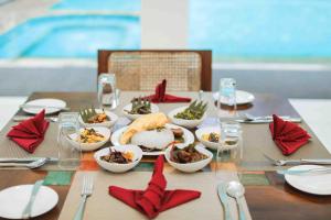 a table with bowls of food and red napkins at Palmstone Retreat in Kitulgala