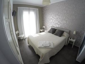 1 dormitorio con cama blanca y ventana en Hostal Mediterráneo, en Tossa de Mar