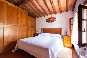 Un dormitorio con una cama y armarios de madera. en Casa Paola, en Camaiore