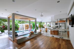 a large kitchen and living room with wooden floors at 4BR Villa Minggu - Minggu Villas Seminyak in Seminyak