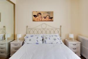 1 dormitorio con 1 cama blanca y 2 mesitas de noche en A Cuerpo de Rey * Centro de Ávila, en Ávila