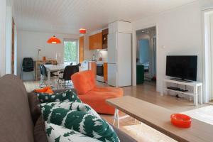 a living room with a couch and a table and a kitchen at Archipelago-house with pool, boat and bikes in Djurhamn