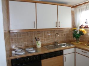 a kitchen with white cabinets and a sink at Ferienwohnung in Bohndorf