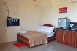 um pequeno quarto com uma cama e um micro-ondas em Vidas Mountain Stay-Bohol em Baclayon