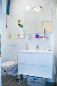 een badkamer met een wastafel, een toilet en een spiegel bij Apartment D&T in Split