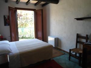 1 dormitorio con cama blanca y ventana en La Lepre Bianca, en Cento