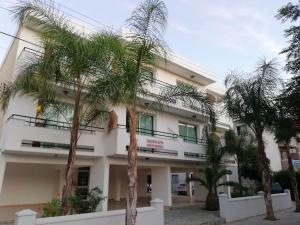 a building with palm trees in front of it at Marianna Hotel Apartments in Limassol