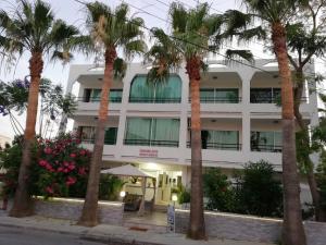 a hotel with palm trees in front of it at Marianna Hotel Apartments in Limassol