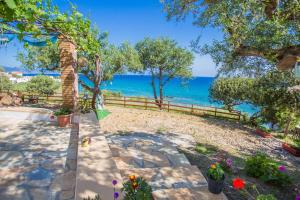 a garden with a view of the ocean at Ammos Apartments in Alikanas