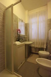 e bagno con servizi igienici, lavandino e doccia. di monforte view apartment a Monforte dʼAlba