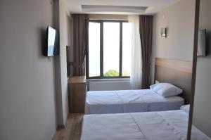 a hotel room with two beds and a television at Longoz Hotel in Igneada +51 photos