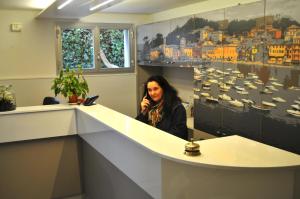 Una donna seduta al bancone di un ufficio di Hotel Villa Rosa a Sestri Levante