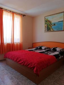 een slaapkamer met een bed met een rood dekbed bij Apartments Bravo 1-Vichevi in Sunny Beach +75 foto's