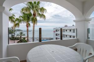 balcón con mesa y vistas al océano en Apartamentos Ros, en Santa Eulària des Riu