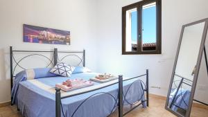 een slaapkamer met een blauw bed en 2 spiegels bij Villa Cigaline in Tiggiano