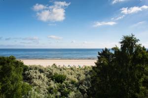 a view of a beach with trees and the ocean at Hotel Villa Seeschlößchen in Ahlbeck