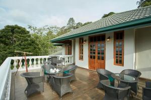 a balcony with chairs and tables on a house at Manor House Boutique Villa in Bandarawela