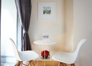 two white chairs and a table in a room with a window at 横浜ザ・アパートメント in Yokohama