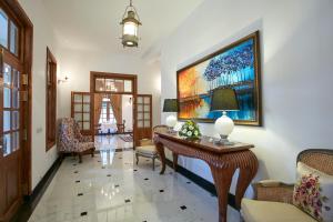 una sala de estar con una mesa y una pintura en la pared en Manor House Boutique Villa en Bandarawela