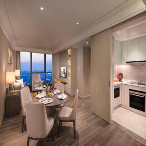 a dining room and kitchen with a table and chairs at Ascott Harmony City Nantong in Nantong