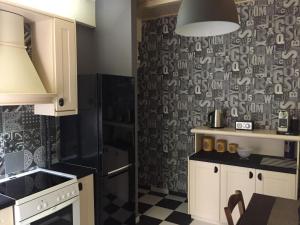 een keuken met een zwart-witte muur bij Cosy and comfort flat, heart of Athens in Athene