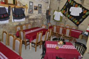 a restaurant with red tables and chairs and clothes hanging on the wall at "Pivnica i smestaj Jovanovic"- Rogljevacke pivnice in Rogljevo