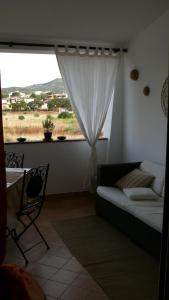 salon z kanapą i oknem w obiekcie Sardegna casa al mare San Teodoro Vaccileddi Porto San Paolo w mieście Porto San Paolo