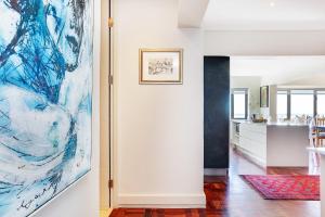 a living room with a painting on the wall at Backup Powered Sea View Apartment on the Promenade in Cape Town