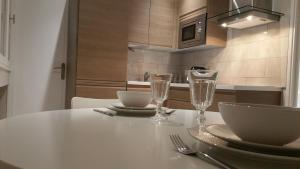 - une table blanche avec des assiettes et des verres dans l'établissement Appartement de la Richelandiere, à Saint-Étienne