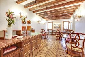 a kitchen with wooden cabinets and a dining room with a table at Hotel Casanova in Venice