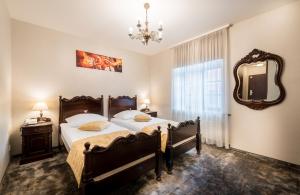 sypialnia z 2 łóżkami i lustrem w obiekcie Gotyk w Toruniu