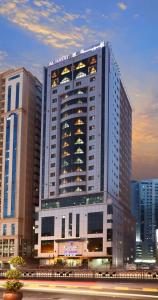 a large building with lights on in a city at Al Hayat Hotel Suites in Sharjah