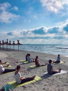 people sitting on top of a sandy beach at Nayino Resort Hotel in Mamaia Nord