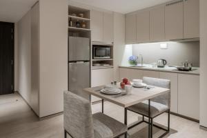 a kitchen with a table and chairs in a room at Le Grove Serviced Residences in Singapore