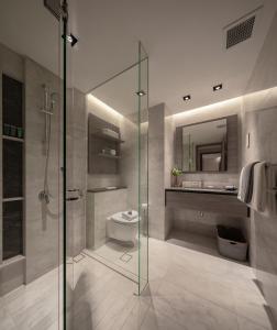 a bathroom with a glass shower and a toilet at Le Grove Serviced Residences in Singapore
