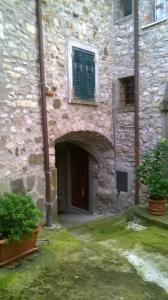 a stone building with a door and a window at Cà Ermenegarda in Bagnone