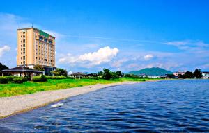 a building on the side of a body of water at Imazu Sun Bridge Hotel in Takashima