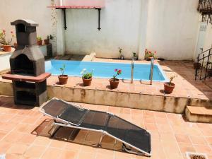 einen Pool mit Grill und Topfpflanzen um ihn herum in der Unterkunft Estudio El Zoco in Granada