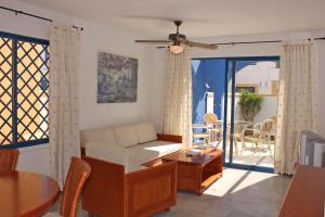 uma sala de estar com um sofá e uma mesa em Apartamentos El Minarete em Roquetas de Mar