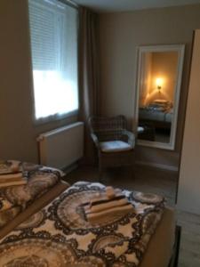 een slaapkamer met 2 bedden en een spiegel bij Ferienwohnung Eckloff in Lutherstadt Wittenberg