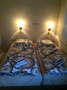 two beds in a small room with lights on the wall at Ferienwohnung Eckloff in Lutherstadt Wittenberg