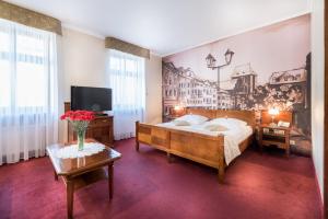 托倫的住宿－格泰科酒店，卧室配有一张床,墙上挂有绘画作品