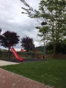 a playground with a red slide in a park at Casa-Apartamento Madera y Sol in Lubia