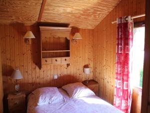 a bedroom with a bed and a window in it at Nice chalet with dishwasher, in the High Vosges in Le Thillot