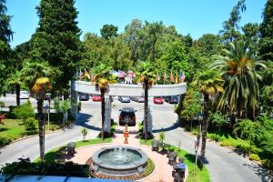 a fountain in the middle of a road with trees at Hotel Intourist Palace Batumi in Batumi