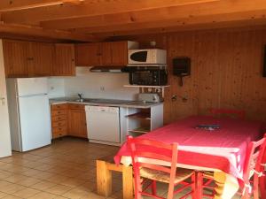 a kitchen with a table with a red table cloth on it at Comfy chalet with dishwasher, in the High Vosges in Le Ménil