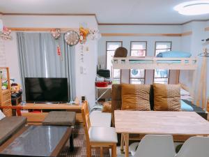 a living room with a couch and bunk beds at Ryokoheya Hankyukan in Osaka