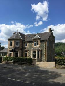 a large brick house on the side of a street at Fernbank House in Aberfeldy